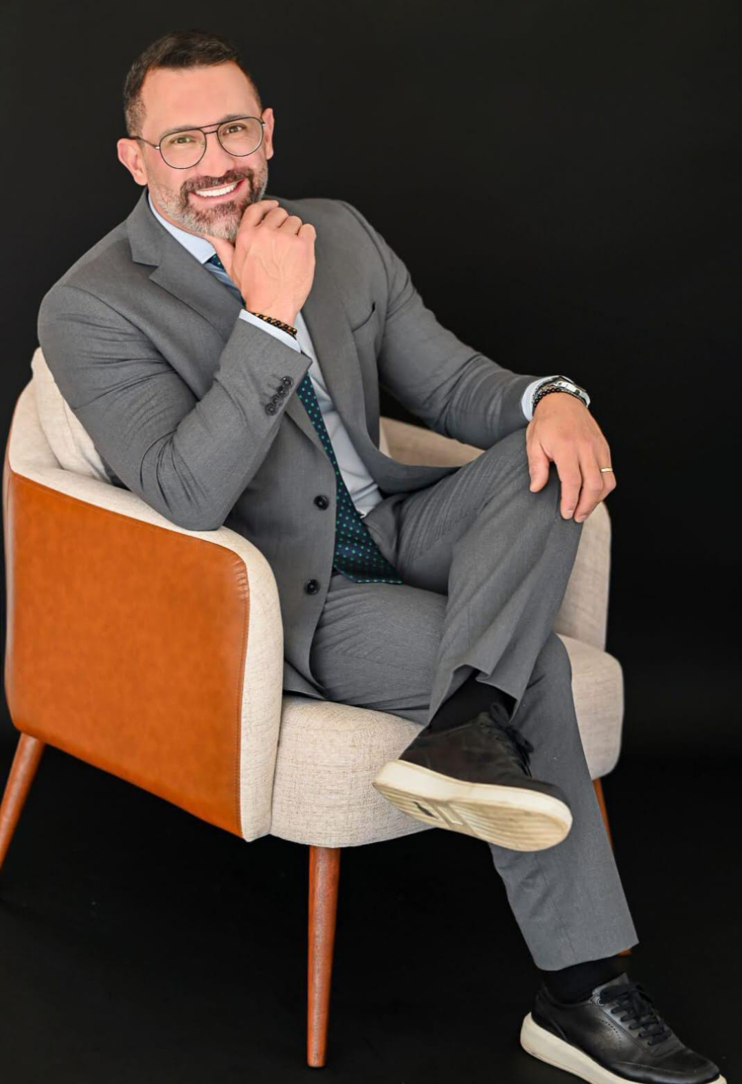 Retrato do advogado Douglas Dall Cortivo dos Santos sentado em poltrona